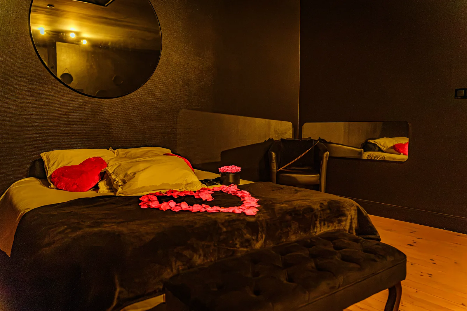 Cœur de pétales de roses sur le lit de la suite